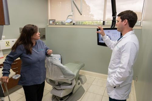 Dentist and dental hygienist having a discussion in dental exam room