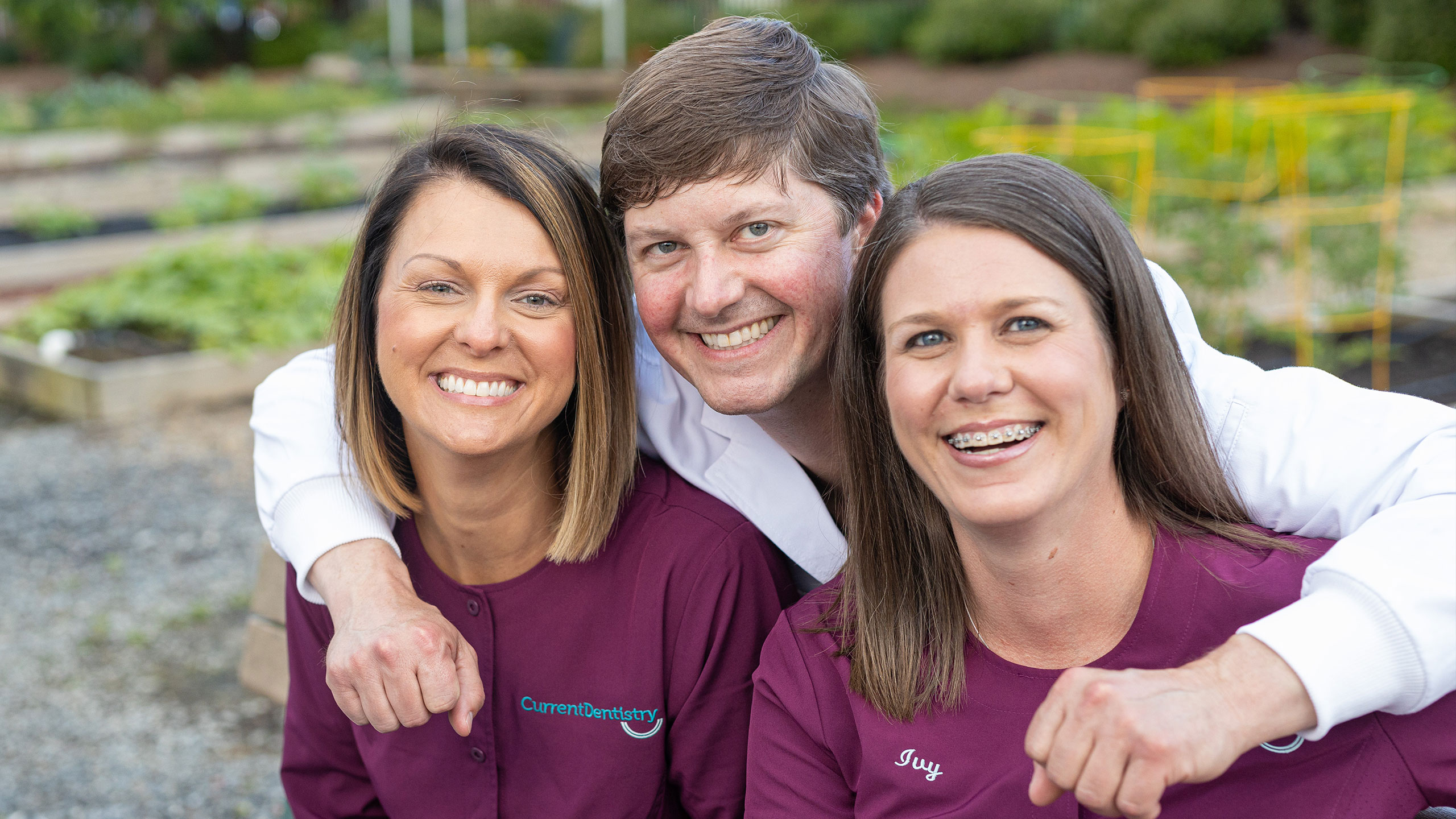 Dentist with Arms Around Assistants